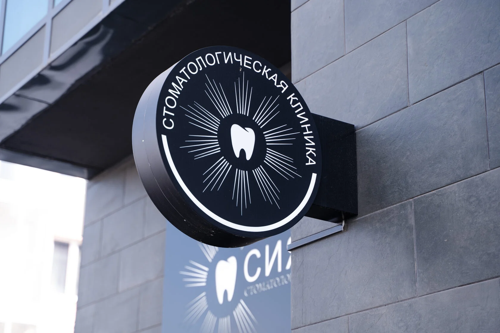Вывеска стоматологической клиники «Сияние» на фасаде здания
